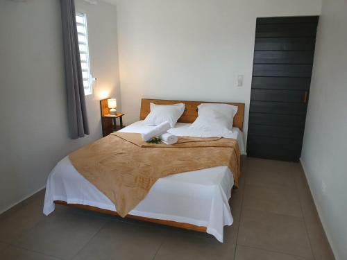 a bedroom with a large bed with white sheets and pillows at Écrin d'évasion in Sainte-Anne