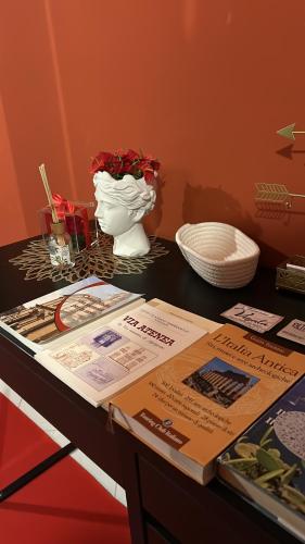 a table with a vase and a table with papers on it at B&b regina del porto in Porto Empedocle