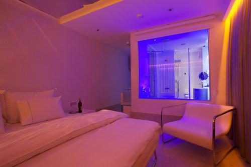 a bedroom with a bed and a window with purple lights at Venn Boutique Hotel in Samsun