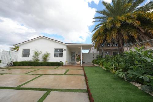 una casa blanca con una palmera y un patio en E&A SouthWest Miami - Breeze Studio, en Lindgren