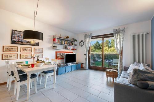eine Küche und ein Wohnzimmer mit einem Tisch und einer Couch in der Unterkunft Blu Oltrelago Pool & Lake - Happy Rentals in Leggiuno