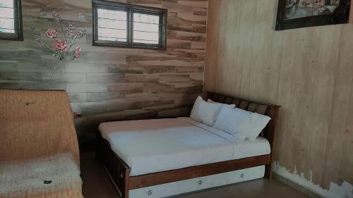 Teratak Jannah Homestay & Resort في كوالا لكانغسار: غرفة نوم بها سرير في جدار خشبي