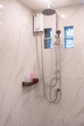 a shower in a white bathroom with a shower at Capitel Sathorn in Yan Nawa