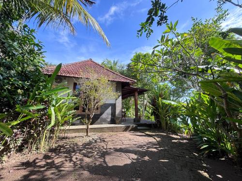 a small house in the middle of a garden at Balian River Hut in Balian