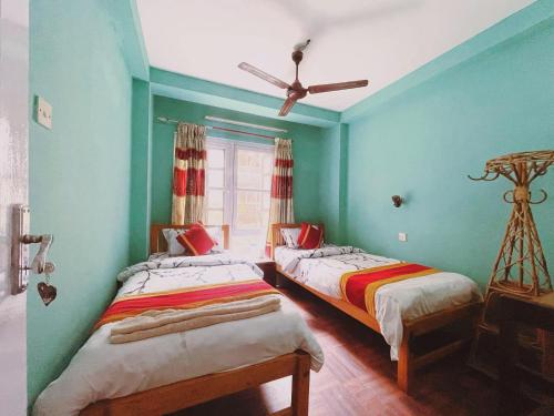 two beds in a room with blue walls at Hotel Pokhara Peace in Kathmandu