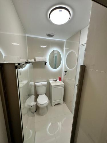 圣胡安Kantares Guest a 4 min Aeropuerto的带马桶和镜子的白色浴室