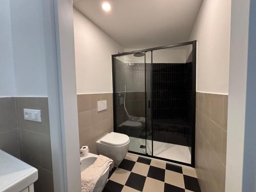 a bathroom with a toilet and a glass shower at Cà du Local in Arenzano