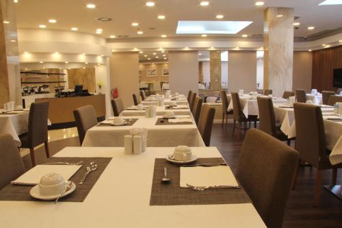 a dining room with white tables and chairs at Masa Hotel Almirante in Lisbon