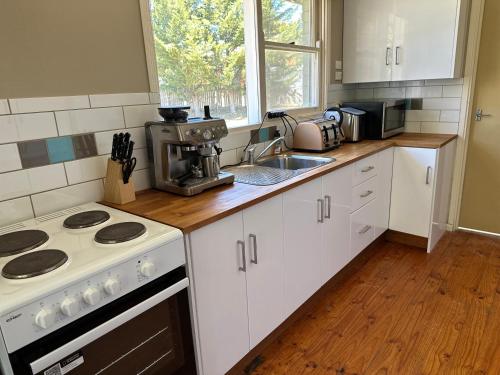 Canberra Hospital Locum Welcome Entire Family Home في Phillip: مطبخ بخزائن بيضاء وفرن موقد