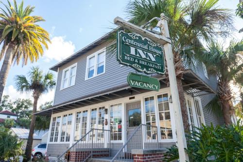 a sign in front of a house with palm trees at Carriage Way Centennial House - Adult Only- Saint Augustine in St. Augustine