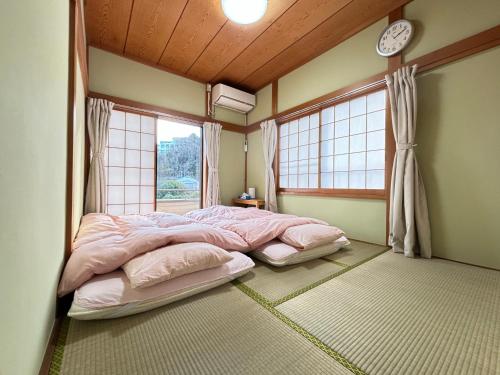 a bedroom with a large bed and a window at 一棟貸しの宿 貸別荘 水戸ハウス Vacation Rental Mito House! Location is 1-2-55 Kanemachi Ibaraki Prefecture 場所は茨城県水戸市金町1-2-55です ドア横のキーボックスの番号はご予約後に,チェックイン情報を見る,をご覧下さい in Mito