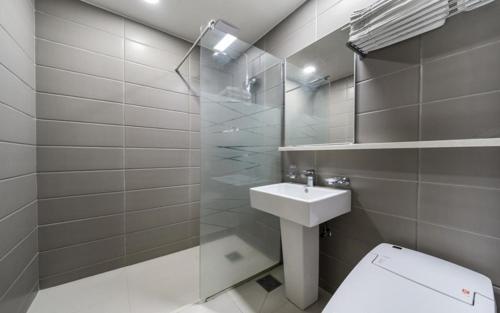 a bathroom with a toilet and a sink and a shower at Noble Hotel in Yeosu