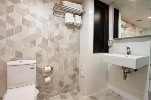 a bathroom with a sink and a toilet and a mirror at Hotel Z zpaze in Bangkok
