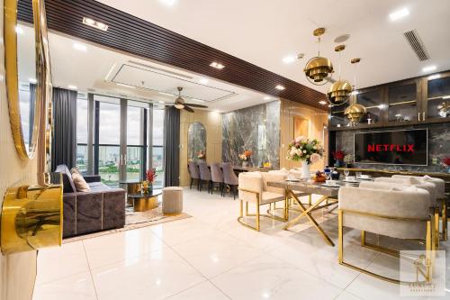 a living room with a table and a dining room at The Majesty Landmark 81 Residence in Ho Chi Minh City