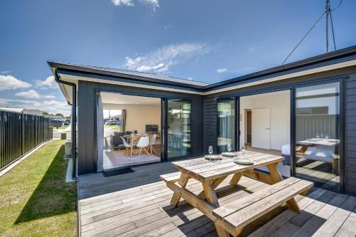 a deck with a wooden picnic table on a house at Quiet on Cassin - Taradale in Napier
