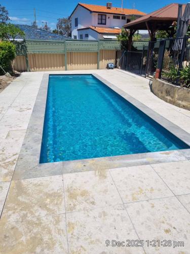 a swimming pool with blue water in a yard at Angel Apartment in Perth
