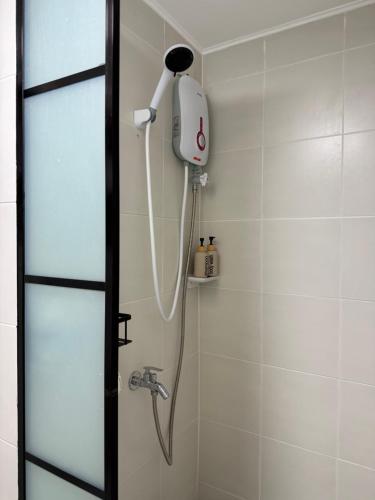 una ducha con cabezal de ducha en un baño en The UrbanNest, en Piapi