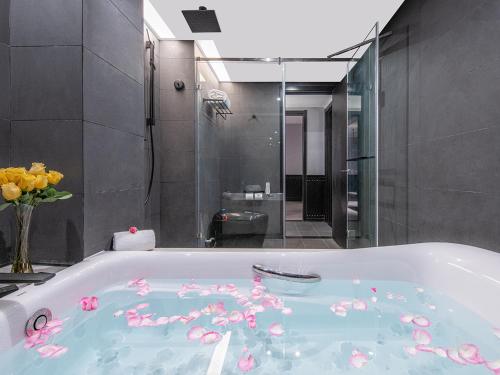 een badkamer met een bad gevuld met roze bloemen bij Orange Chengdu Jinniu Wanda Hotel in Chengdu