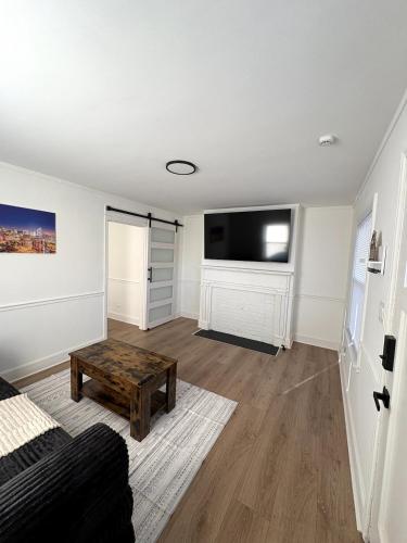 a living room with a couch and a flat screen tv at Charming Classic, duplex Home with a Modern Twist in Charlotte