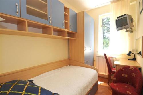 a bedroom with a bed and a desk and a tv at Apartman-studio Adriana 3 in Lovran