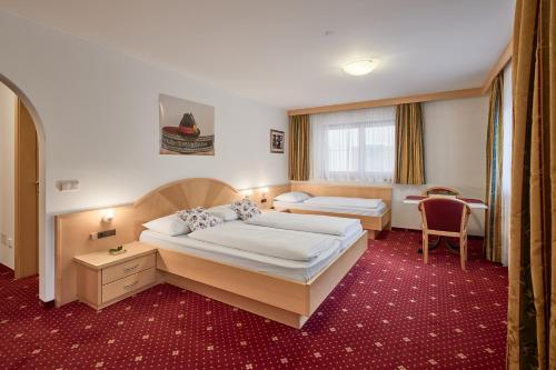 a hotel room with two beds and a chair at Zimmervermietung Zum Weissen Rössl in Sarntal