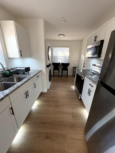 a kitchen with white cabinets and a sink and a table at Charming Classic, duplex Home with a Modern Twist in Charlotte