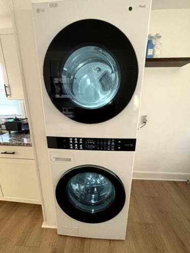 a washer and dryer in a cabinet in a kitchen at Charming Classic, duplex Home with a Modern Twist in Charlotte