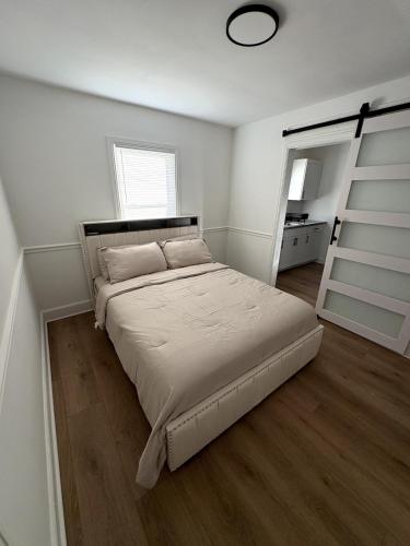a white bedroom with a bed and a window at Charming Classic, duplex Home with a Modern Twist in Charlotte