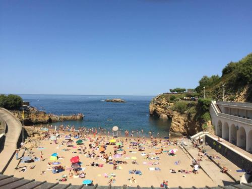 a beach filled with lots of beach chairs and umbrellas at Le Gamaritz in Biarritz