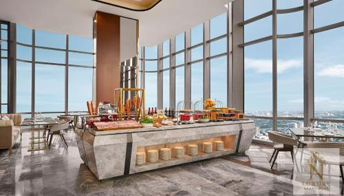 a breakfast buffet in a restaurant with large windows at The Majesty Landmark 81 Residence in Ho Chi Minh City