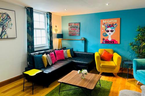 a living room with a black couch and a yellow chair at Pebble Mews House By My Getaways Parking in Brighton & Hove