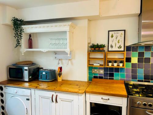 a kitchen with a counter top with a microwave at Pebble Mews House By My Getaways Parking in Brighton & Hove
