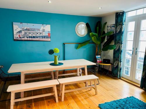 a table and benches in a room with a blue wall at Pebble Mews House By My Getaways Parking in Brighton & Hove
