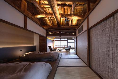 een slaapkamer met twee bedden en een houten plafond bij 中尾甚六hotel in Karatsu