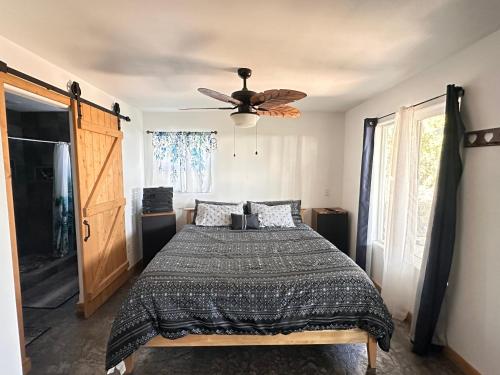 a bedroom with a bed and a ceiling fan at The Gray House 