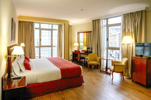a hotel room with a bed and a desk at Gran Hotel de Ferrol in Ferrol