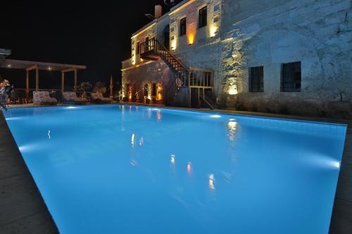 a large swimming pool in front of a building at night at Shoestring Cave House in Goreme