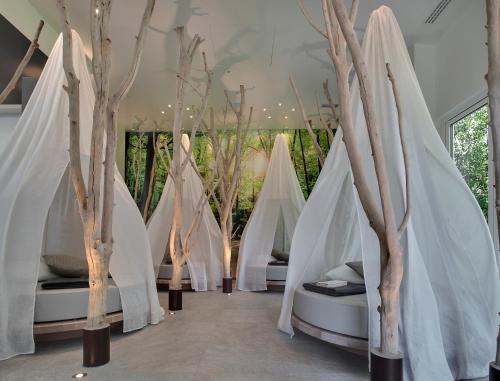 a room with white canopy beds with trees at Hotel Mioni Pezzato in Abano Terme