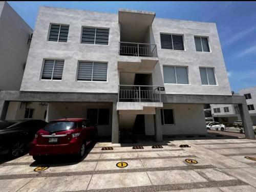 a red car parked in front of a building at Condominio mzt in Mazatlán
