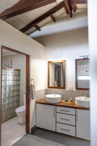 a bathroom with two sinks and a toilet at Whispering Palms - Absolute Beachfront Villas in Port Vila