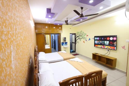 a hospital room with three beds and a flat screen tv at Bluetique Beach House in Kuilapayam