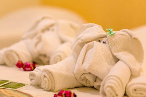 a towel animal is laying on a bed at Pousada Etoile in Juquei