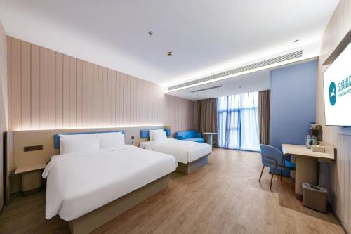 Una habitación de hotel con una cama grande y un escritorio. en Hanting Hotel Shanghai Pudong Airport Shixin Road, en Shanghái