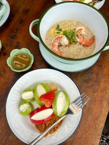 - une table avec un bol de soupe et une assiette de nourriture dans l'établissement Lantamangrove, à Ban Ru Yai
