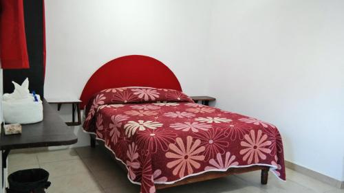 sypialnia z czerwonym łóżkiem i czerwonym krzesłem w obiekcie Juan Pablo II w mieście San Martín Texmelucan de Labastida