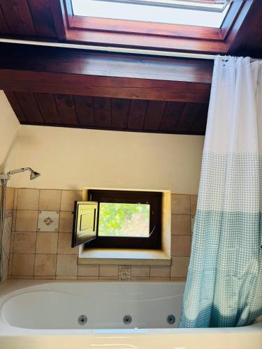 a bathroom with a bath tub with a television on the wall at Il Casale di Luisa in Modica