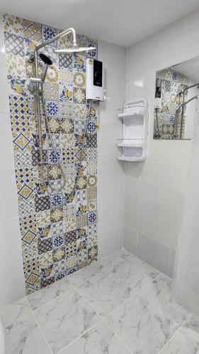 a bathroom with a shower with a tiled wall at BaanMalee Homestay in Buriram