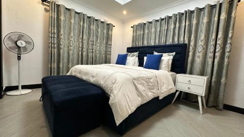 a bedroom with a blue bed and a blue chair at Beauty Blender Homes - The Executive House in Lilongwe