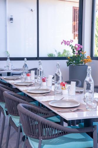 een lange tafel met stoelen en glazen flessen erop bij Sunwave Dhigurah in Dhigurah