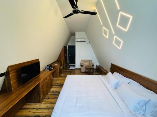 Schlafzimmer im Dachgeschoss mit einem Bett und einem TV in der Unterkunft Mangalath River View Resorts in Kodanad